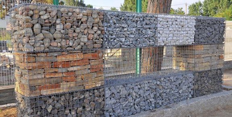 Muro feito de pedras redondas, preso com rede de arame de aço (gabião de  pedra de ferro)